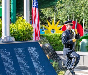Coral Gables Police Lt. Nestor Carbonell marches past the monument at the Youth that bears the names of local sons and daughters who never returned home from war as part of the city’s Memorial Day ceremony May 26. (Photo: Noomi Herran, City of Coral Gables)