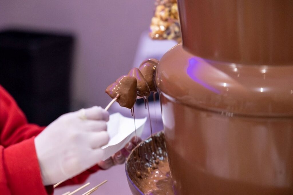 Close-up of fruit being dipped into a chocolate fountain at Fairchild Tropical Botanic Garden’s Festival of Chocolate.