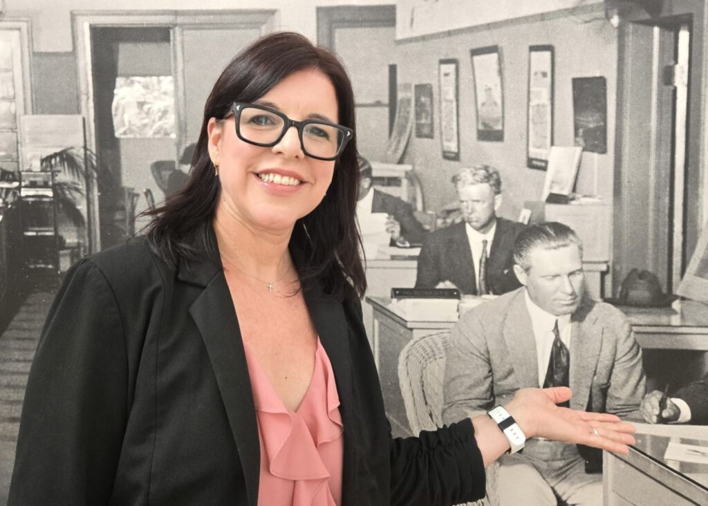Yuni Villalonga, Director of Curatorial Programs, speaks with visitors inside the Coral Gables Museum, explaining the themes and curatorial decisions behind a current exhibition.