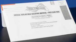 Close-up of an official Miami-Dade County vote-by-mail ballot envelope labeled “Official Election Mail” and “Business Reply Mail.”