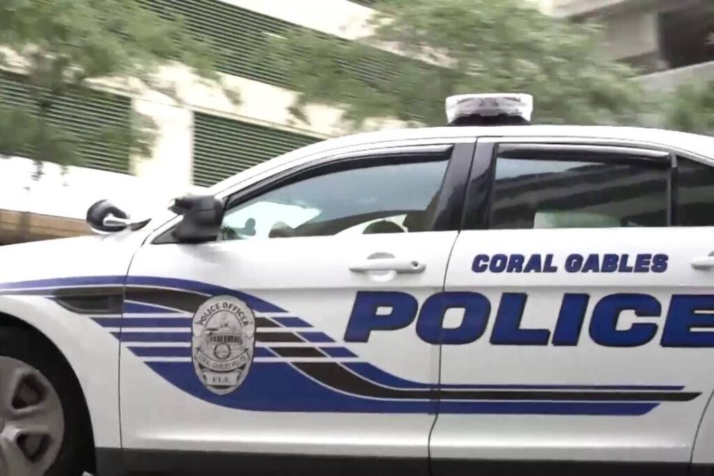 Side view of a Coral Gables Police patrol car with department markings and blue lettering.