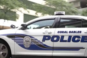 Side view of a Coral Gables Police patrol car with department markings and blue lettering.