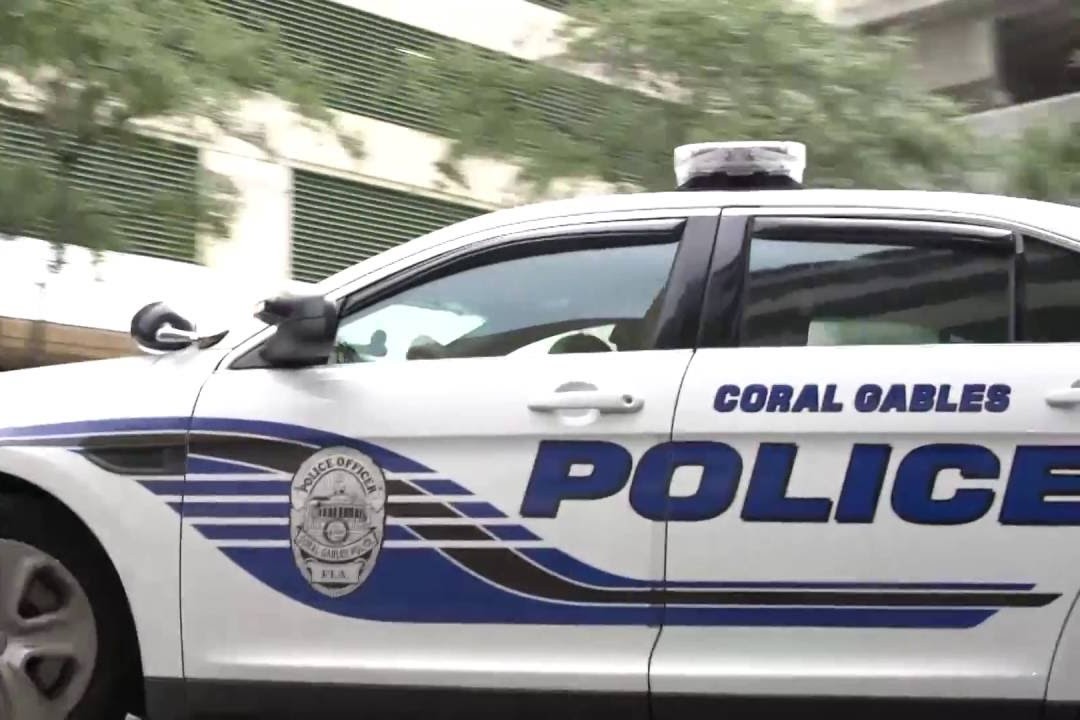 Side view of a Coral Gables Police patrol car with department markings and blue lettering.