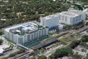 Aerial rendering of The Mark, a proposed mixed-use development in Coral Gables along South Dixie Highway, showing a large multi-story residential complex with rooftop amenities adjacent to the University Metrorail station.
