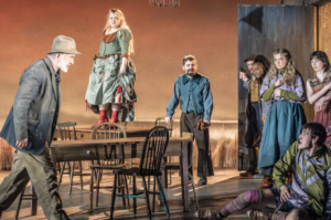 Stage scene from The Playboy of the Western World showing multiple actors in period Irish costumes gathered around a wooden table, with one woman standing atop it as others react dramatically in a rustic interior set.