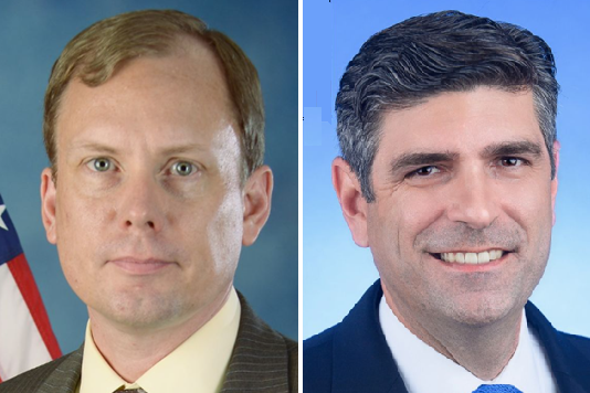 Side-by-side professional headshots of two men. At left, Keith Puls, a fair-skinned man in a light shirt and tie with an American flag visible behind him. At right, Ignacio Vazquez, a man with dark hair in a dark suit and tie against a light blue background. Both face the camera directly.