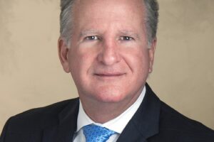 Formal headshot of Coral Gables City Manager Peter Iglesias wearing a dark suit and blue tie.