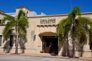 Exterior of the Coral Gables Museum at 285 Aragon Avenue, with palm trees framing the entrance.