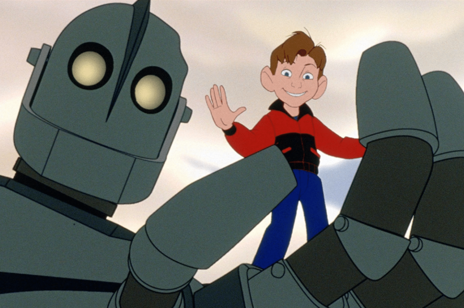 Animated scene from The Iron Giant showing a young boy standing in the hand of a large robot.