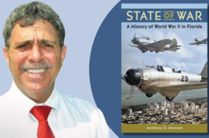 Anthony D. Atwood shown beside the cover of State of War: A History of World War II in Florida, which features World War II aircraft over Florida.