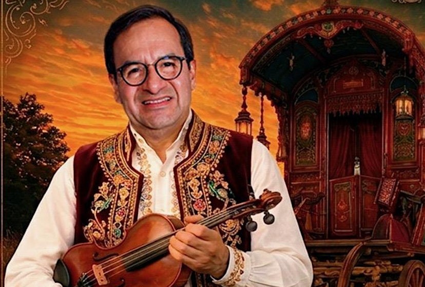 Man wearing an embroidered vest holds a violin in front of a stylized sunset scene with an ornate caravan in the background.