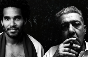 Black-and-white composite portrait of two men against a dark background, one facing the camera and the other holding a cigar near his mouth.
