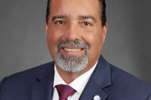 Headshot of Rafael Villalobos, incoming superintendent of Miami-Dade County Public Schools, wearing a dark suit and red tie.