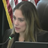 Coral Gables Commissioner Melissa Castro speaks into a microphone from the dais during a City Commission meeting.