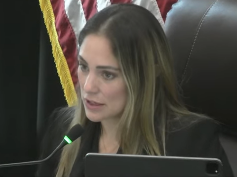 Coral Gables Commissioner Melissa Castro speaks into a microphone from the dais during a City Commission meeting.