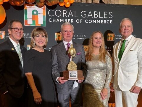 From left, Jorge Martinez, Gloria V. Baez, Armando Codina holding the George E. Merrick Award, Maria Garcia and W. Allen Morris pose in front of a Coral Gables Chamber of Commerce backdrop.
