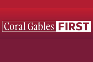Coral Gables First logo in white lettering on a red and burgundy background.