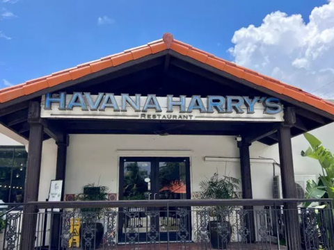 Exterior of Havana Harry’s restaurant in Coral Gables, with its large sign above the entrance under a red-tile roof.