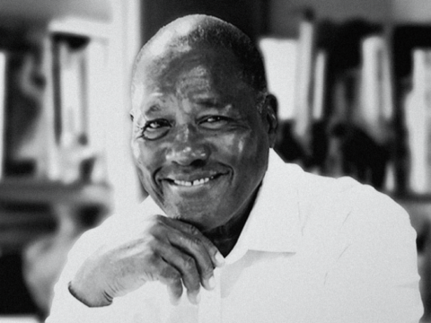 Black-and-white portrait of historian Marvin Dunn smiling with his hand resting beneath his chin.