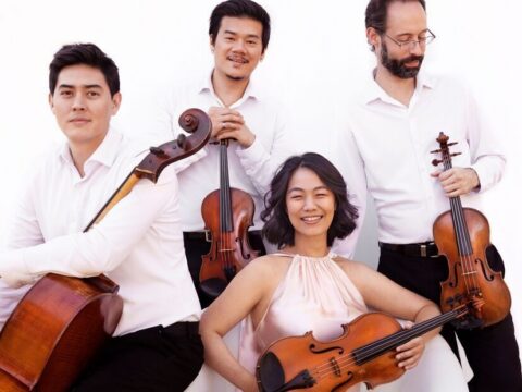 Four members of the Telegraph Quartet pose with two violins, a viola and a cello against a white background.