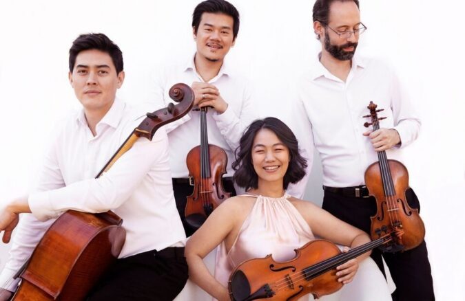 Four members of the Telegraph Quartet pose with two violins, a viola and a cello against a white background.