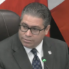 oral Gables Commissioner Ariel Fernandez, wearing glasses and a dark suit, sits at the commission dais beside a microphone during his final meeting Oct. 27, 2026.