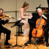 Scott Flavin plays violin, Lindsay Garritson plays piano and Ross Harbaugh plays cello during a Bergonzi Piano Trio performance.