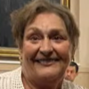 llen Uguccioni smiles inside the Coral Gables City Hall Commission Chambers, with framed artwork and flags visible behind her.