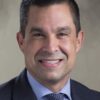 Lago raises $57,750 in two days while linked PAC holds estimated $249,000 Head-and-shoulders portrait of Coral Gables Mayor Vince Lago smiling in a dark suit, blue checked shirt and patterned tie against a neutral background.
