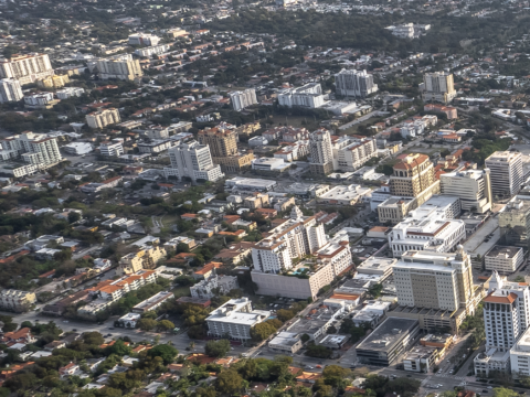 Aerial photograph of Coral Gables' North Ponce area, showing mid-rise and high-rise buildings, intersecting streets and tree-lined residential neighborhoods.