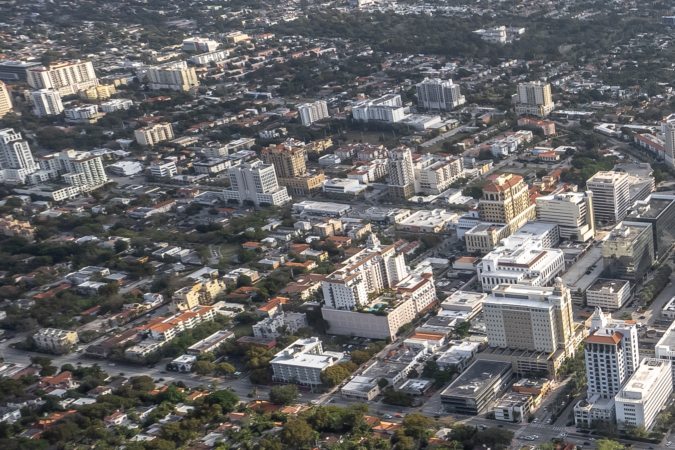 Aerial photograph of Coral Gables' North Ponce area, showing mid-rise and high-rise buildings, intersecting streets and tree-lined residential neighborhoods.