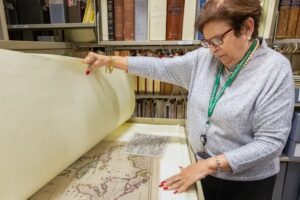 Gladys Gómez-Rossié looks through archival maps in the Cuban Heritage Collection. (Photo: Joshua Prezant/University of Miami)